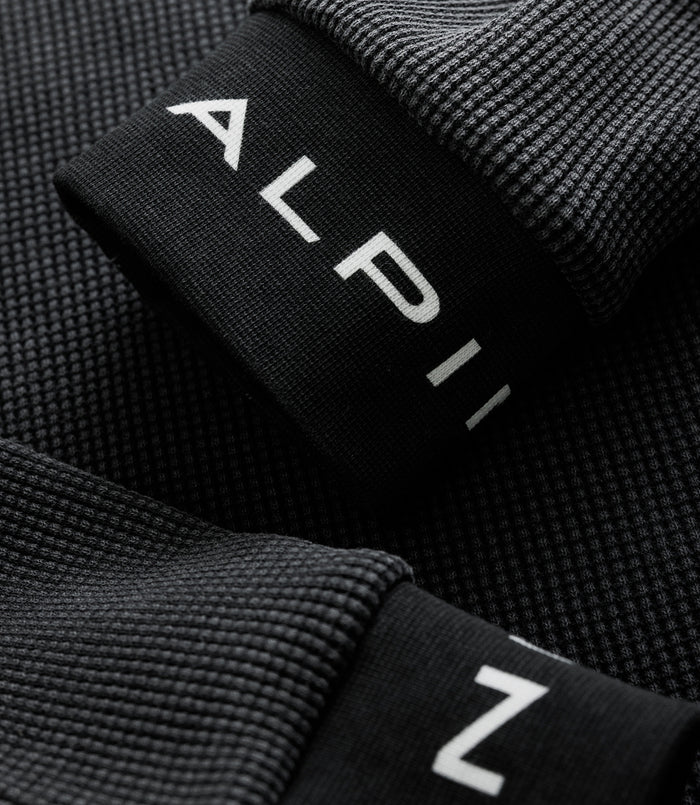 Close up of black jersey edge showing white Alpine letters printed on the fabric fold