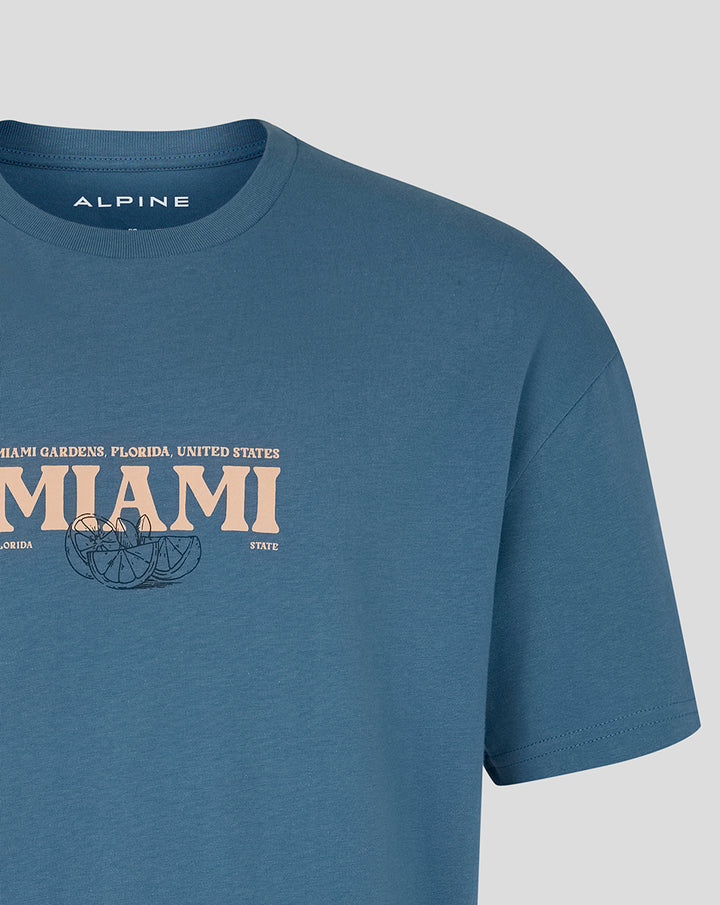 Midsection of blue Miami Race Graphic T Shirt with large MIAMI lettering and citrus illustration across the chest