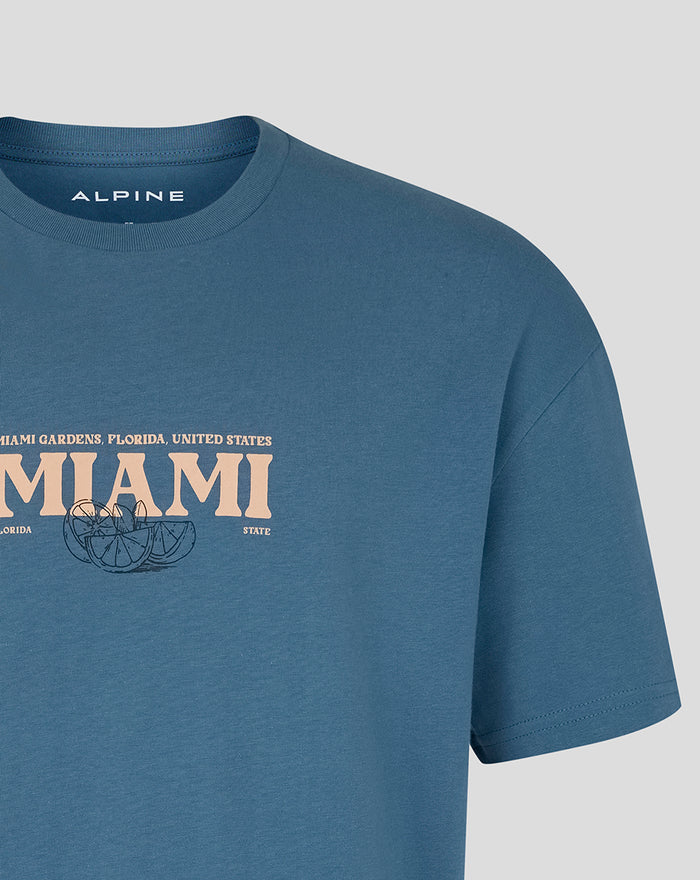 Midsection of blue Miami Race Graphic T Shirt with large MIAMI lettering and citrus illustration across the chest