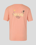 Back view of coral pink Miami graphic T-shirt with large MIAMI text and tropical flamingos and citrus slices.