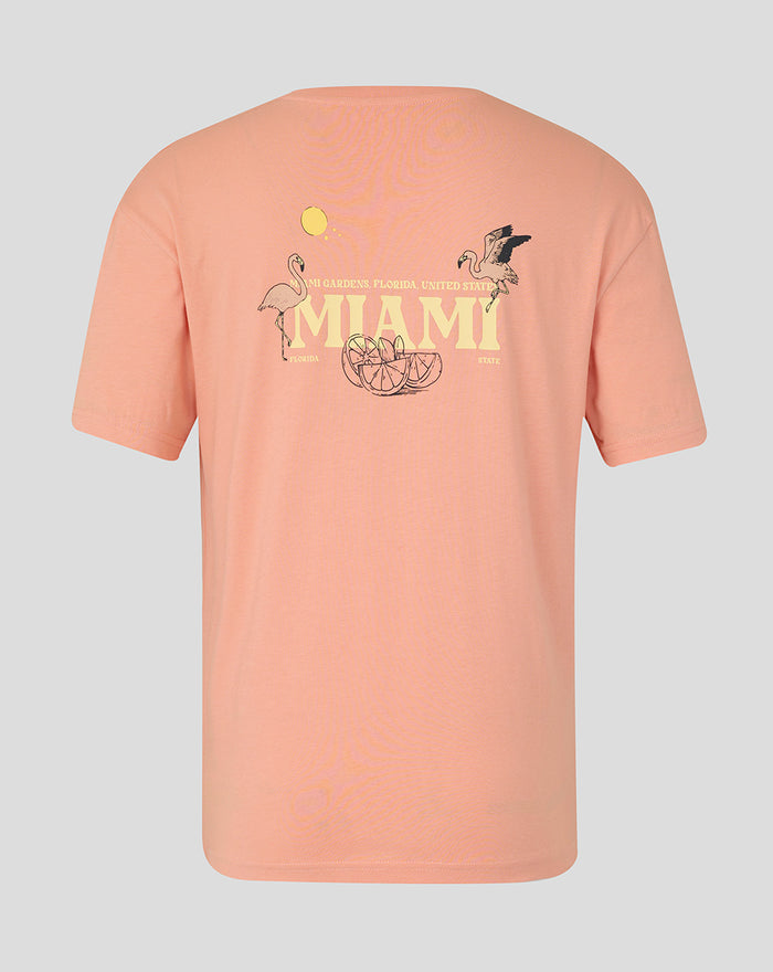 Back view of coral pink Miami graphic T-shirt with large MIAMI text and tropical flamingos and citrus slices.