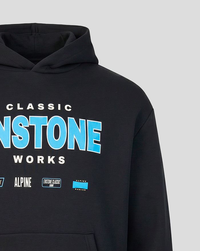 Close up of chest graphic on black hoodie showing bold ENSTONE lettering and part of the hood