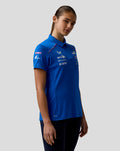 Side view of a model in a blue BWT Alpine Polo Shirt with team logos on the chest and sleeve