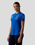 Three-quarter view of a woman in the blue BWT Alpine Driver Set Up T Shirt with sleeve logos visible