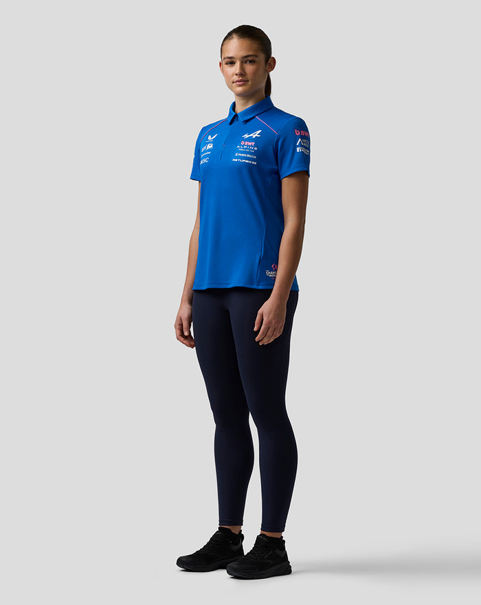 Front view of a woman in a blue BWT Alpine polo with sponsor logos on the chest and sleeve.