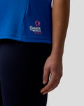 Lower back of blue polo featuring a pink Change the World globe logo