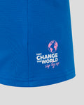 Blue polo shirt fabric close up with Change the World globe logo in white and pink on the hem