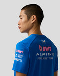 Side view of male model in blue BWT Alpine Formula One Team Set Up T Shirt, showing back logo and shoulder contrast piping