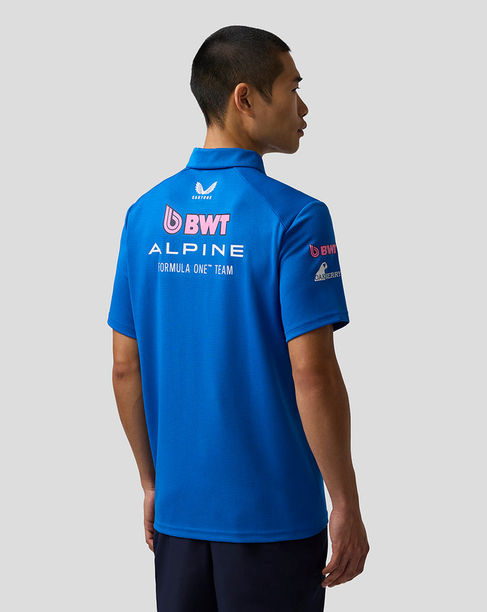 Back view of a blue BWT Alpine Formula One Team polo shirt worn by a model, with team logos on the back.