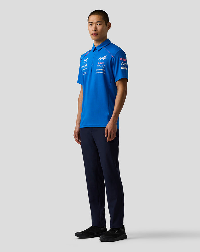 Model wearing a blue BWT Alpine Formula One Team polo shirt with sponsor logos on the chest and sleeve.