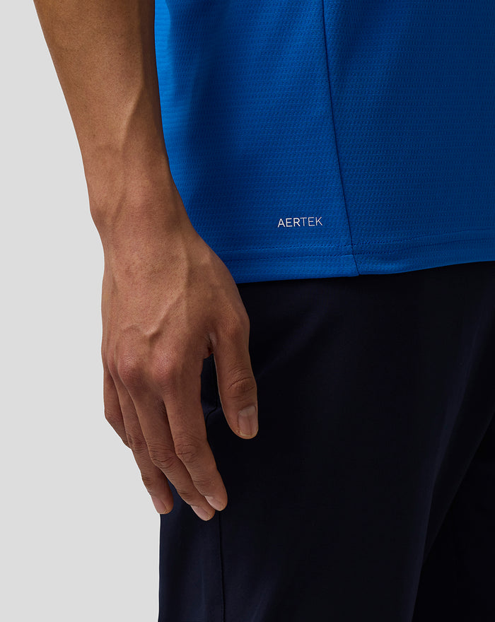 Close-up of the polo hem on the blue Formula One shirt showing AerTek branding