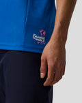 Close-up of the blue polo side hem featuring the Change the World sip by sip logo