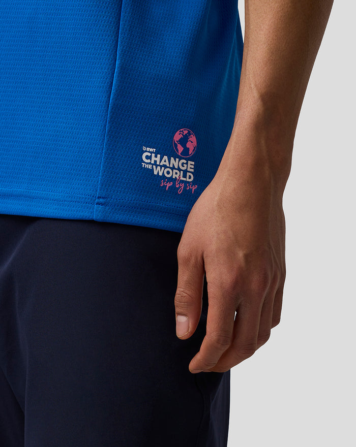 Close-up of the blue polo side hem featuring the Change the World sip by sip logo