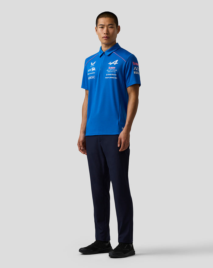 Front view of a man in a bright blue BWT Alpine polo with sponsor logos on the chest and a concealed zip at the collar