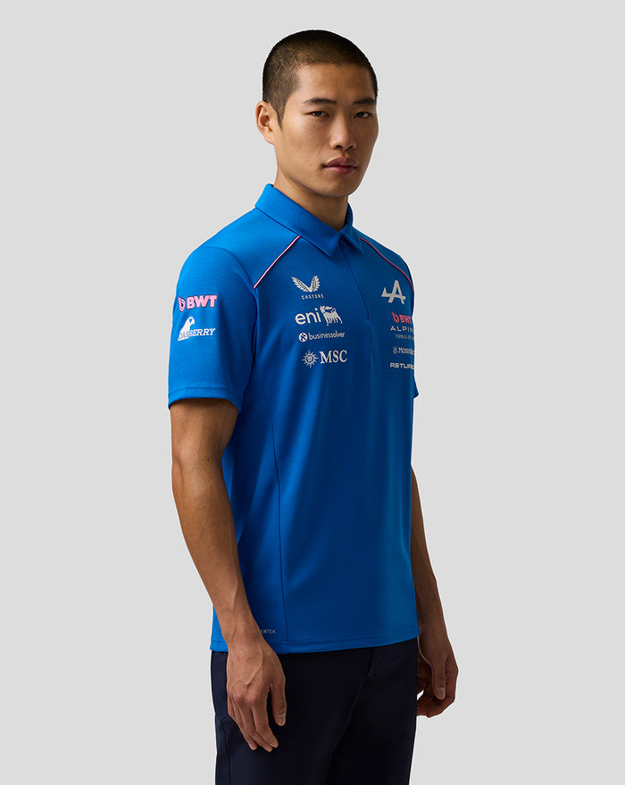 Three quarter front view of a man in a bright blue BWT Alpine polo with sponsor logos across the chest and sleeve