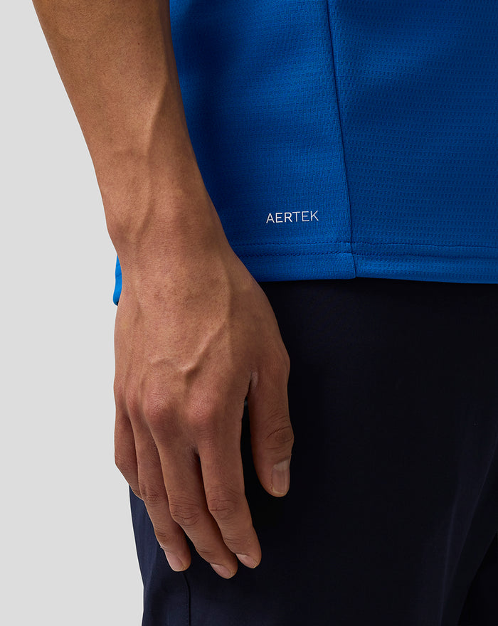 Close up of blue BWT Alpine polo showing AerTek text near the hem and concealed zip puller.