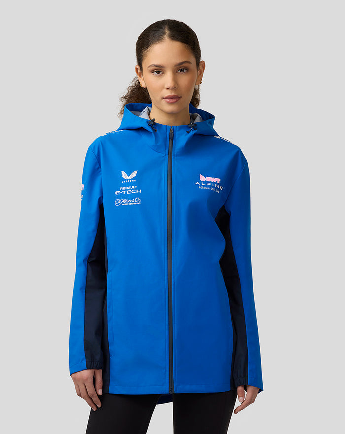 Female model wearing blue BWT Alpine Formula One Team water resistant jacket with hood and sponsor logos.
