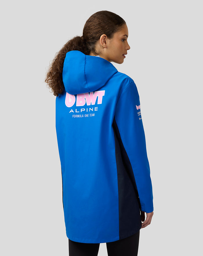 Back view of a woman in a lapis blue BWT Alpine water resistant jacket with a large logo on the back and navy side panels