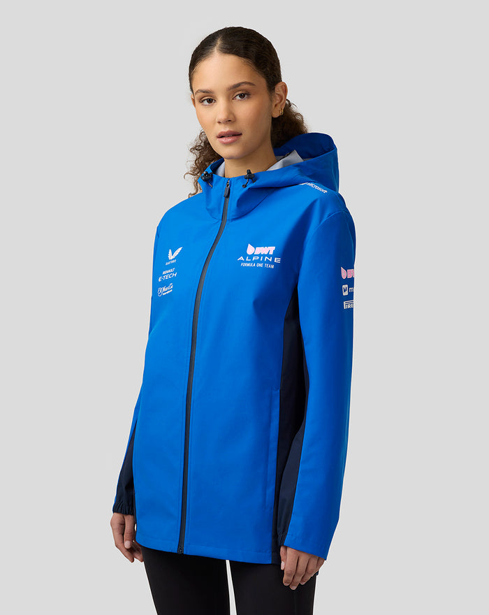 Female model wearing lapis blue BWT Alpine water resistant jacket with hood seen in a three-quarter view.