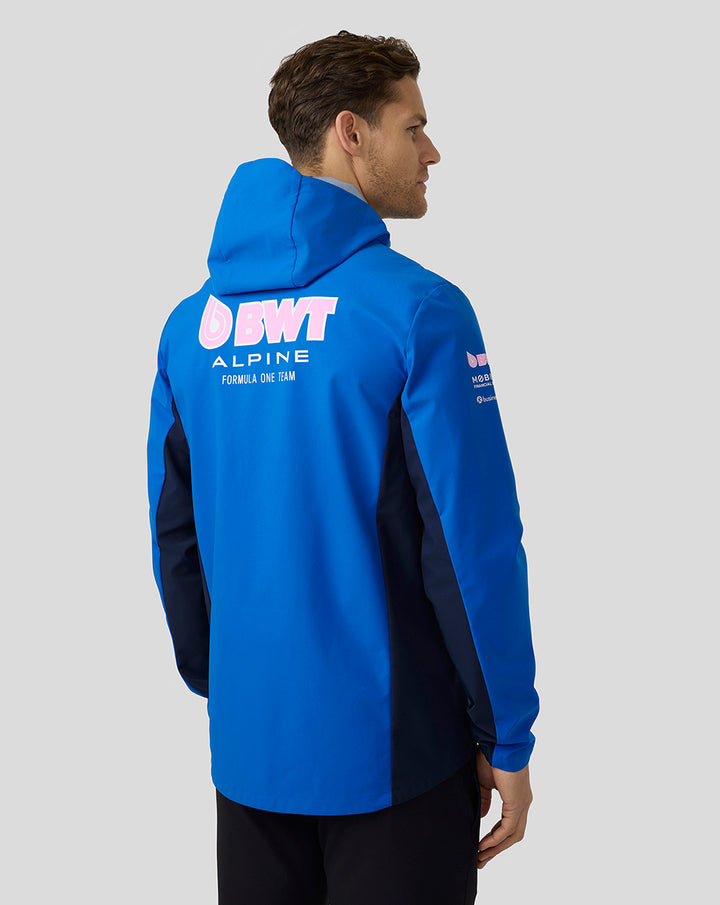 Back view of a male model wearing a lapis blue BWT Alpine water resistant jacket with a large pink BWT logo on the back