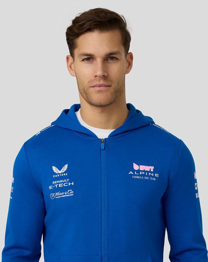 Close up of male model wearing lapis blue BWT Alpine hoodie showing chest branding and sponsor logos.
