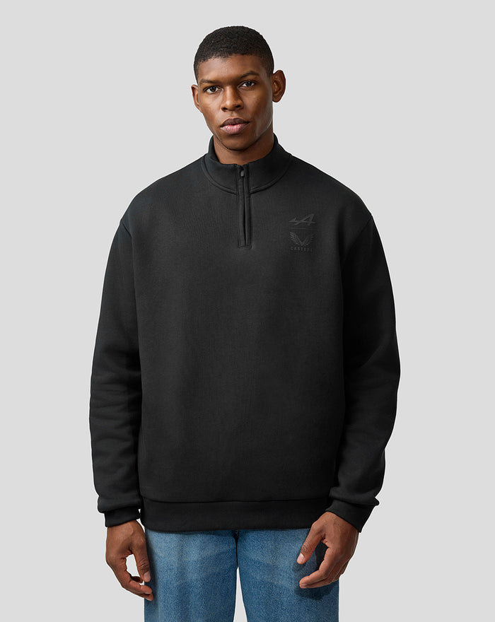 Male model in black unisex quarter zip top with Alpine and Castore chest logos.