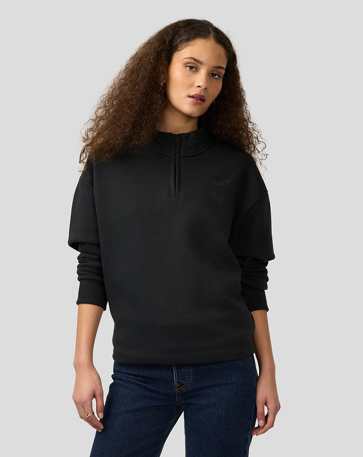 Model wearing black BWT Alpine Castore unisex oversized funnel-neck quarter-zip pullover.