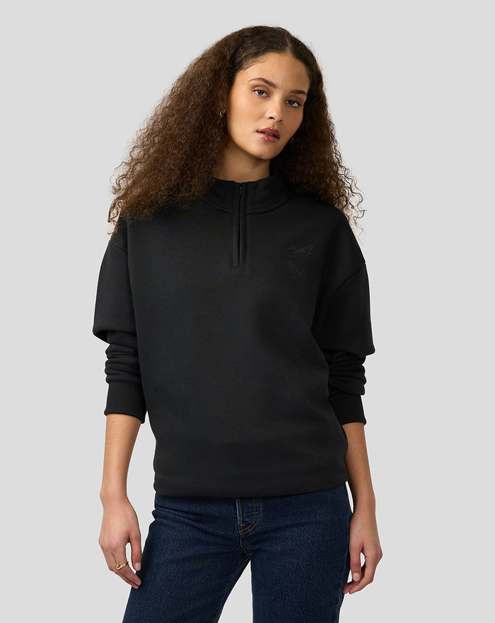 Model wearing black BWT Alpine Castore unisex oversized funnel-neck quarter-zip pullover.