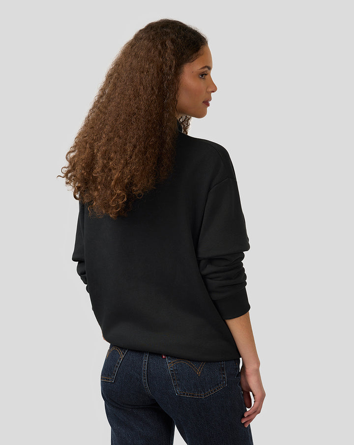 Rear perspective of black unisex quarter-zip pullover with oversized silhouette and ribbed hem