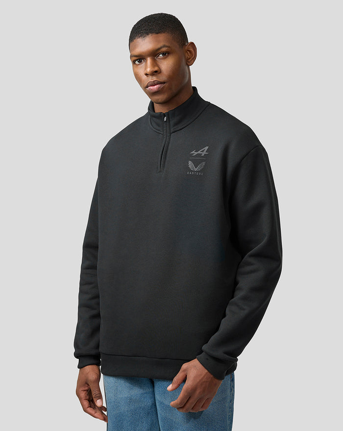 Male model wearing dark Alpine Castore quarter zip fleece with stand collar and chest logo.