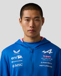 Close up of a man wearing a blue BWT Alpine Formula One Team zip hoodie with white sponsor logos on the chest