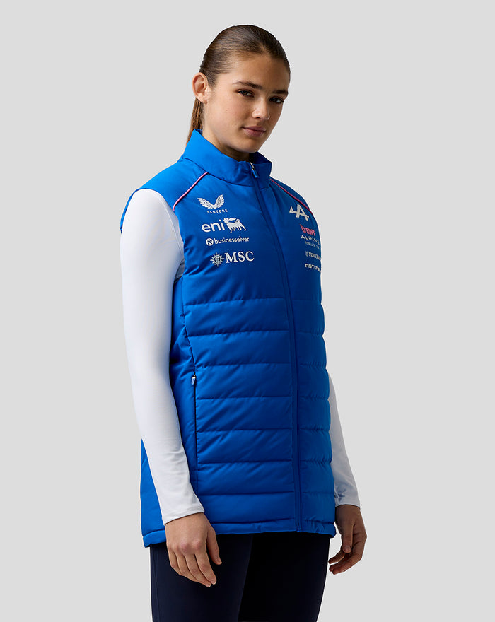 Blue hooded puffer gilet worn by a female model with sponsor logos on chest and sleeve