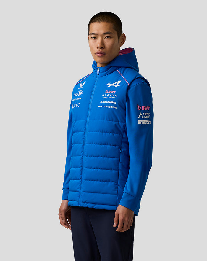 Bright blue hooded puffer gilet worn by a model with Formula One Alpine logos on chest and sleeve