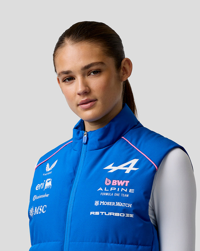 Female model wearing blue BWT Alpine Formula One Team gilet with chest logos and pink piping