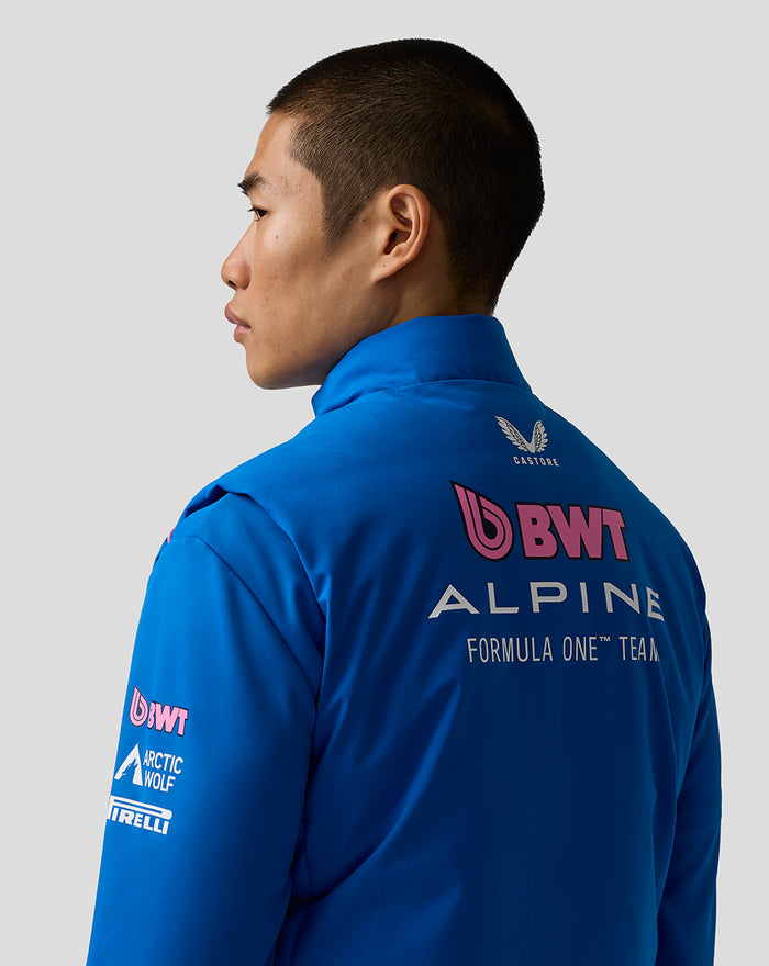 Side/back view of a model wearing the blue BWT Alpine Formula One Team Gilet, showing back logos.