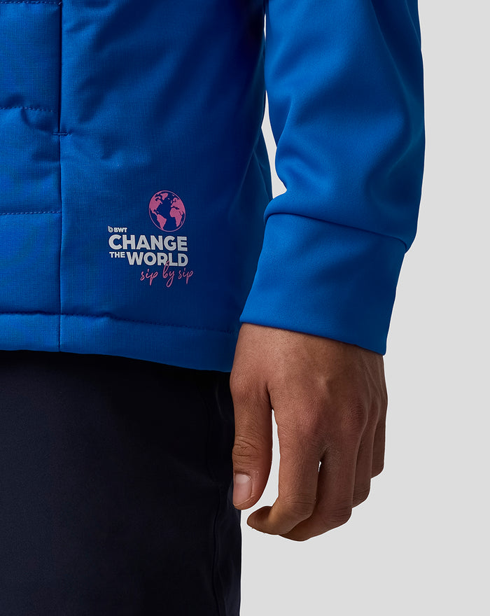 Close-up of the gilet hem with the Change the World logo and globe graphic on blue fabric.