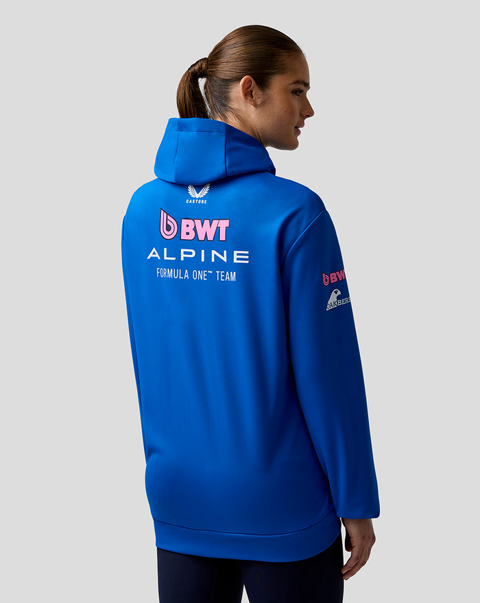 Back view of a blue BWT Alpine Formula One Team hoodie on a female model, with large back logos and chest sponsors.