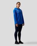 Model wearing blue BWT Alpine Formula One Team hoodie with chest and sleeve sponsor logos