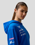 Side profile of a model wearing a blue BWT Alpine Formula One Team hoodie with chest and sleeve logos