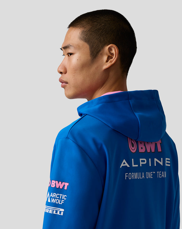 Model wearing blue BWT Alpine Formula One Team hoodie viewed from the back with Alpine branding across the upper back.