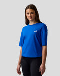 Model wearing lapis blue unisex relaxed fit short sleeve T shirt with embroidered A on the left chest.