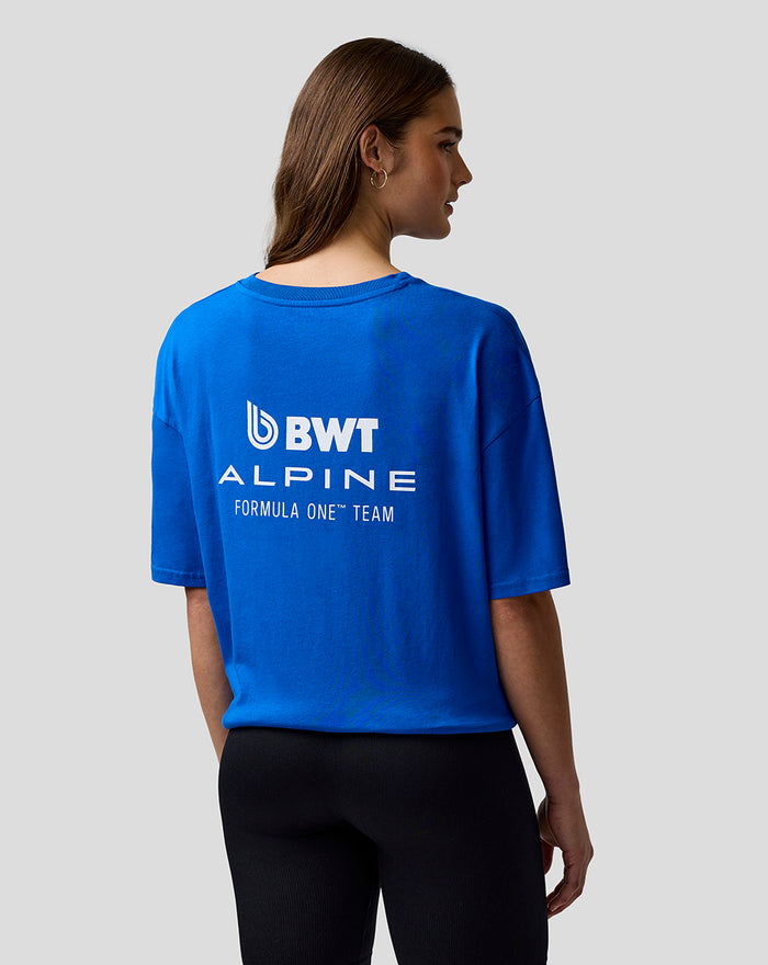Female model in a blue BWT Alpine T shirt seen from behind with a bold logo on the back.
