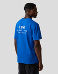 Male model in a blue BWT Alpine relaxed fit T shirt shown from the back with a large white logo on the upper back.