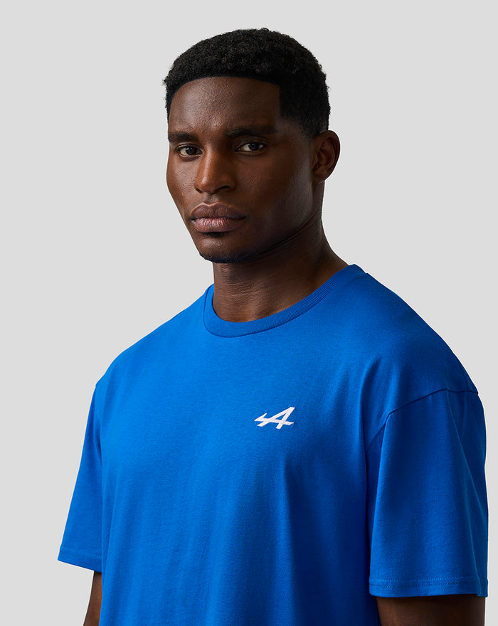 Male model wearing lapis blue relaxed fit T shirt with white embroidered A on left chest