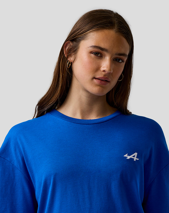 Close up of a woman wearing lapis blue relaxed fit T shirt with white embroidered A on left chest