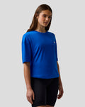 Female model wearing a lapis blue relaxed fit T shirt with an embroidered A logo on the left chest.
