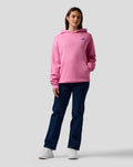 Female model wearing pink core hoodie with relaxed fit and small blue A logo on left chest.