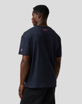 Back view of navy T shirt with pink Alpine branding at upper back and pink A logo on the left sleeve