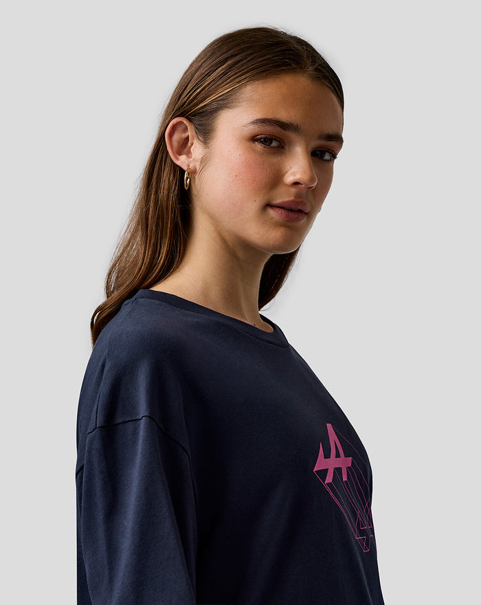 Female model wearing navy Night Sky T shirt with pink Alpine logo on chest and sleeve