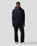 Man in navy Relaxed Fit Graphic Hoodie Night Sky front view with Alpine graphic on the left sleeve
